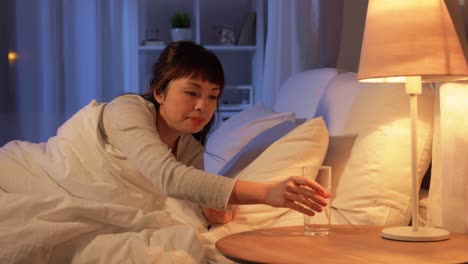 Asian-Woman-Awaking-at-Night-and-Drinking-Water.people,-bedtime-and-thirst-concept-asian-woman-awaking-at-night-and-drinking-water-at-home